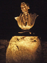 Outdoor accent lighting shines on a historical sculpture.